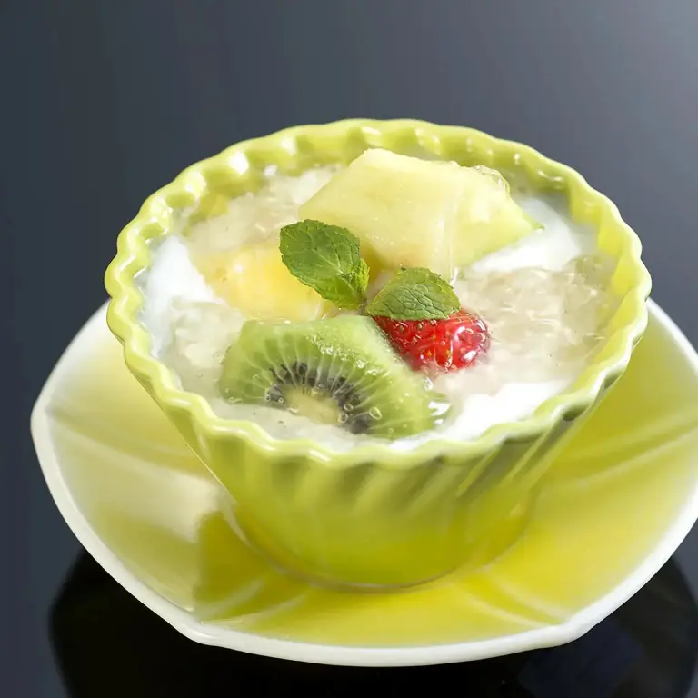 Un dessert à base de fruits frais et de lait de coco est présenté dans un bol en forme de fleur.
