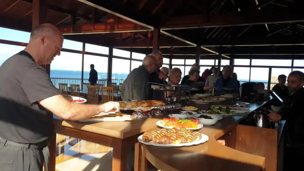 Un buffet est présenté dans une salle lumineuse avec une vue sur la mer.