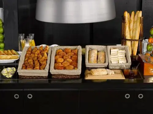 Un buffet propose une variété de viennoiseries et de pains.