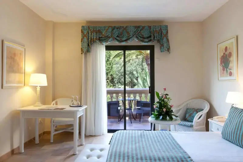 Une chambre lumineuse s'ouvre sur une terrasse avec des meubles de jardin.