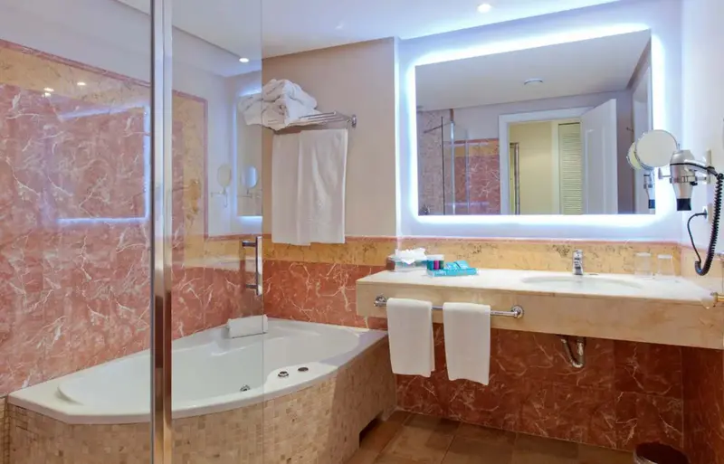 Une salle de bain lumineuse avec baignoire et douche à l'italienne.