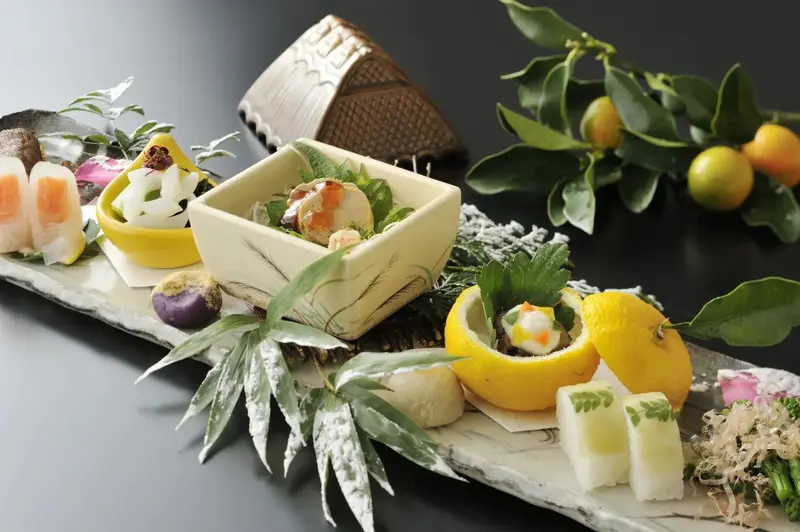 Assortiment de mets raffinés présentés sur une planche en bois et dans des récipients variés.
