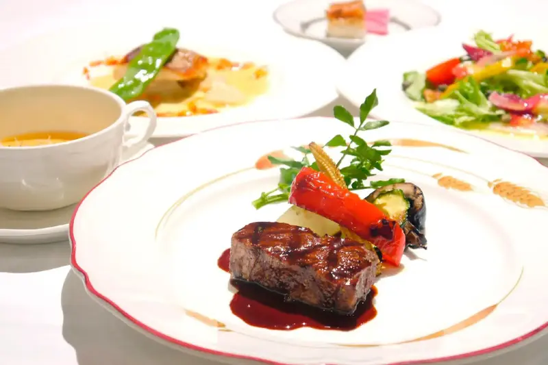 Assiette de viande accompagnée de légumes et d'une sauce.