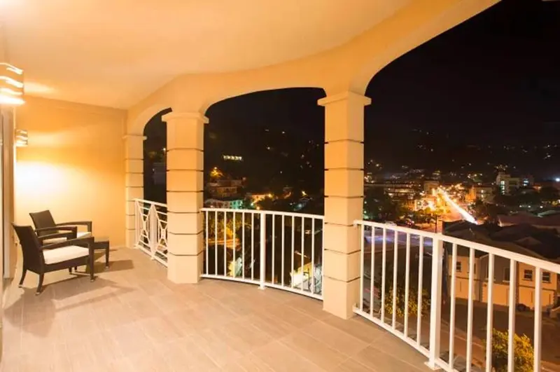 Terrasse avec mobilier d'extérieur donnant sur une ville illuminée la nuit.