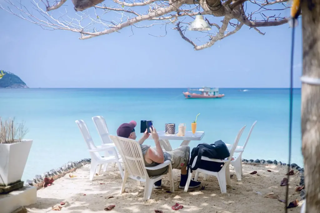 Une personne prend un repas en extérieur face à la mer.