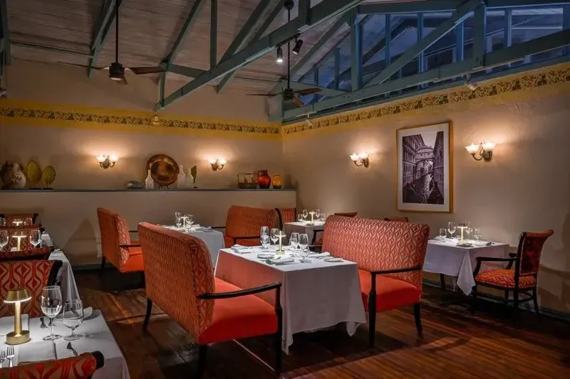 Une salle de restaurant lumineuse avec des tables dressées et des sièges confortables.