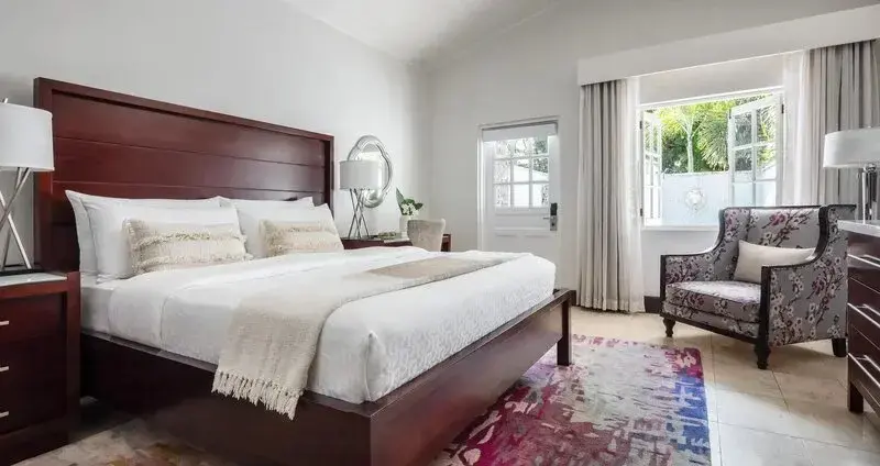Une chambre lumineuse avec un grand lit et un fauteuil.