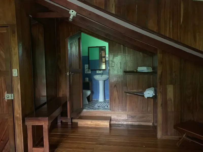 Une salle de bain rustique en bois avec lavabo et douche.