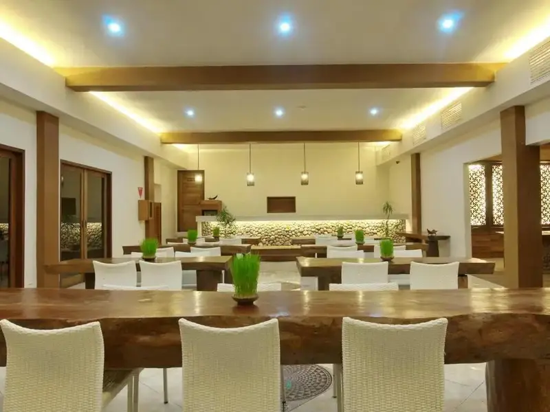 Une salle lumineuse avec des tables et des chaises pour les repas.