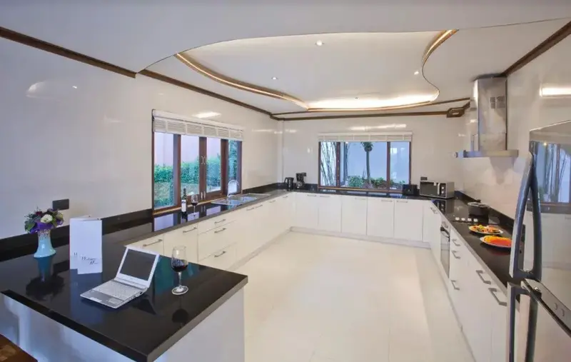 Une cuisine moderne et lumineuse avec un îlot central et des plans de travail en granit.