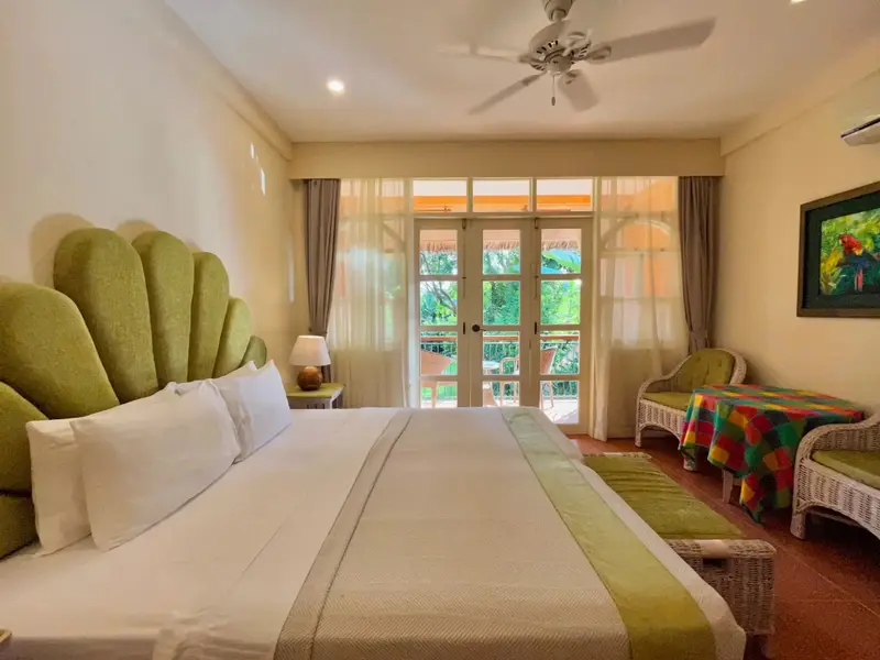 Une chambre lumineuse avec un grand lit et un accès à une terrasse.