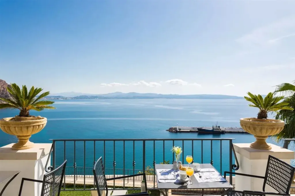 Une table est dressée sur une terrasse avec vue sur la mer.