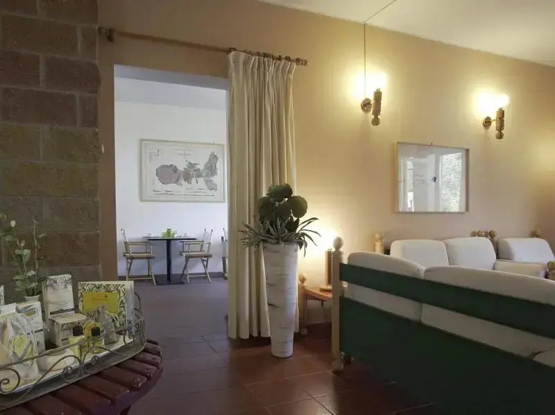 Un espace de séjour lumineux avec un canapé et un coin repas visible au fond.