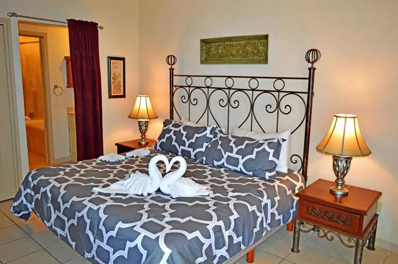 Une chambre décorée avec un lit recouvert d'une courtepointe à motifs et orné de serviettes en forme de cygnes.