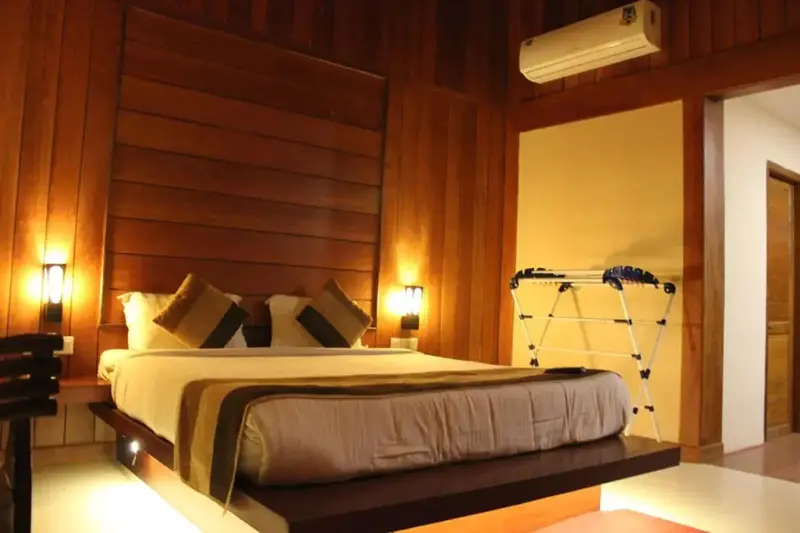 Une chambre lumineuse avec un grand lit et un éclairage chaleureux.