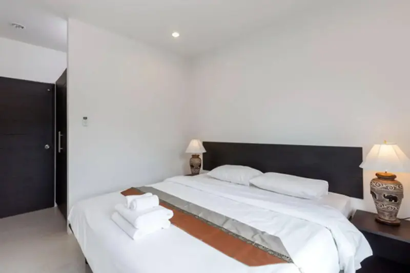 Une chambre lumineuse avec un grand lit et des lampes de chevet.