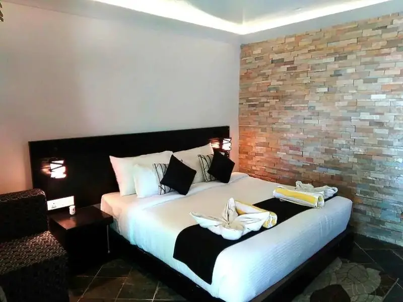 Une chambre avec un grand lit recouvert d'une couette blanche et de décorations.