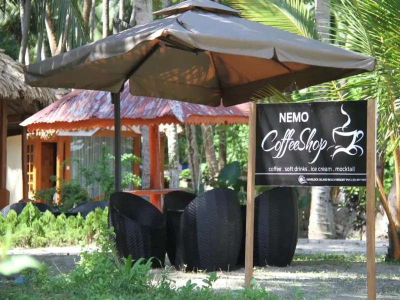 Un café en plein air propose des boissons et des collations dans un cadre tropical.