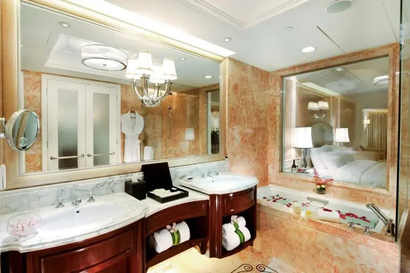 Une salle de bain luxueuse avec deux vasques et une baignoire remplie de pétales de fleurs.