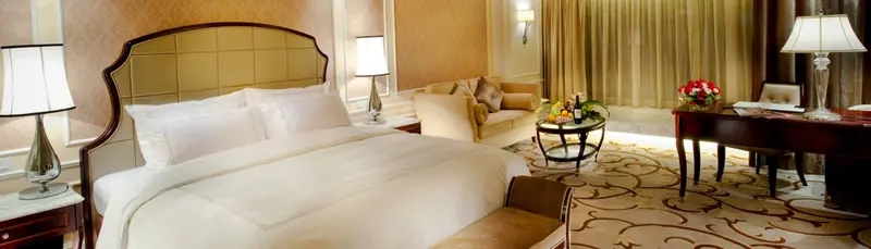 Une chambre lumineuse avec un grand lit et un coin salon.