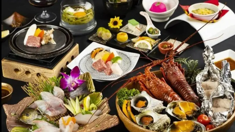 Présentation raffinée de fruits de mer et de plats variés sur une table sombre.