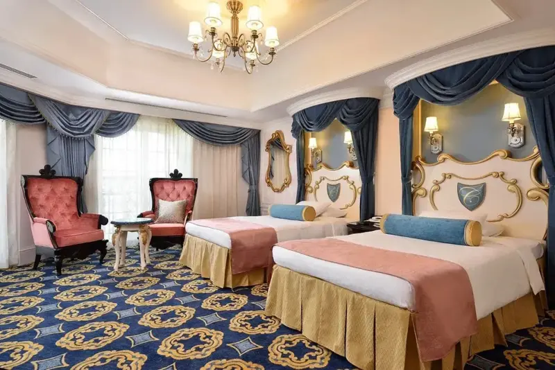 Chambre spacieuse avec deux lits et des fauteuils.