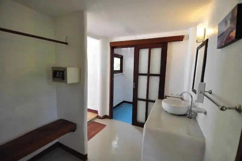 Une salle de bain lumineuse avec une douche visible au fond.