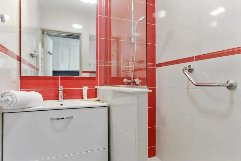 Une salle de bain lumineuse avec une douche et un lavabo.