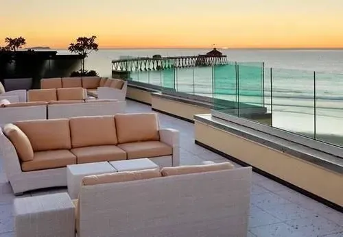 Espace de détente extérieur avec mobilier confortable face à la mer.