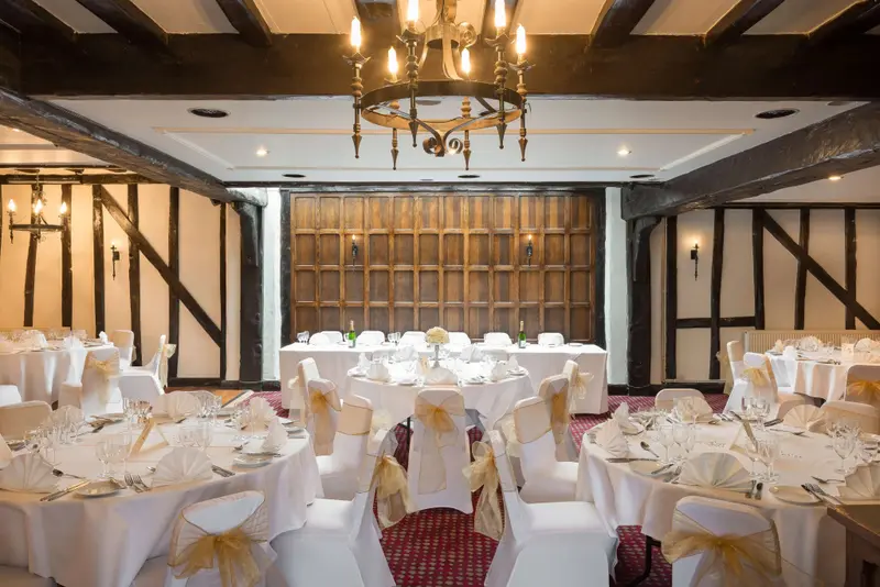 Une salle de réception élégante avec des tables dressées pour un banquet.