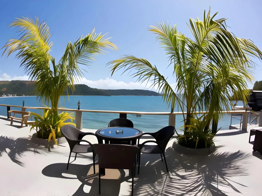 Terrasse avec mobilier de jardin face à la mer.