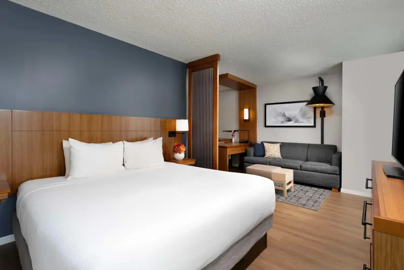 Une chambre lumineuse avec un grand lit et un coin salon.