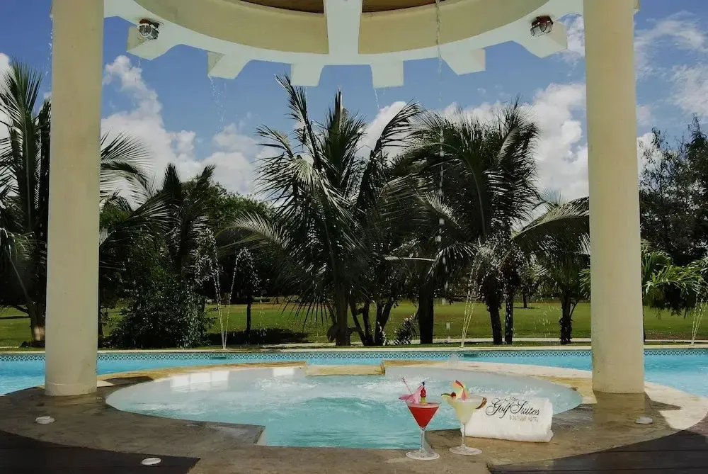 Une piscine circulaire avec des fontaines et des cocktails sur un bord.