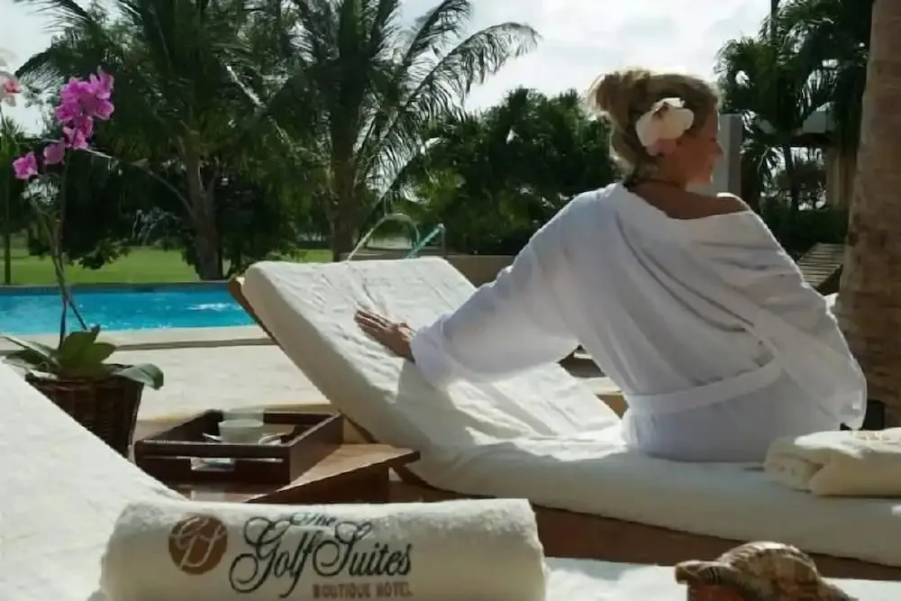 Une femme se détend sur une chaise longue au bord d'une piscine.