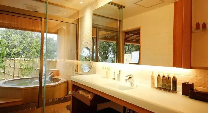 Une salle de bain lumineuse avec une baignoire et un grand miroir.