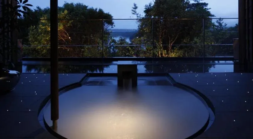 Une piscine intérieure avec une vue sur la mer au crépuscule.
