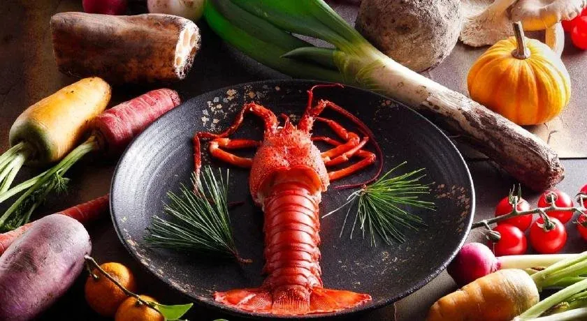 Une assiette de homard est présentée avec des légumes frais.