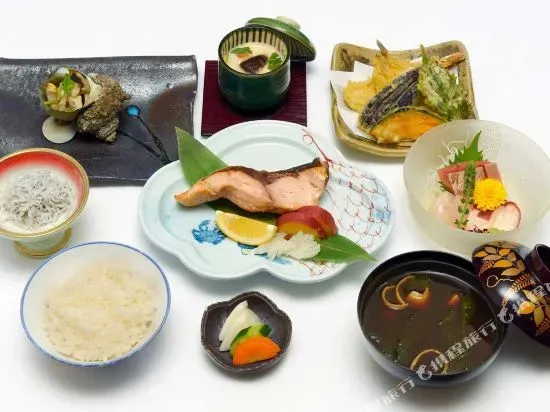 Assortiment de plats traditionnels japonais présentés sur des céramiques colorées.