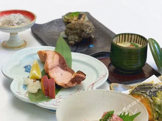 Assortiment de plats japonais servis dans de la vaisselle en céramique.