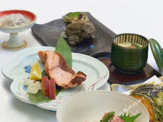 Assortiment de plats japonais servis dans de la vaisselle en céramique.