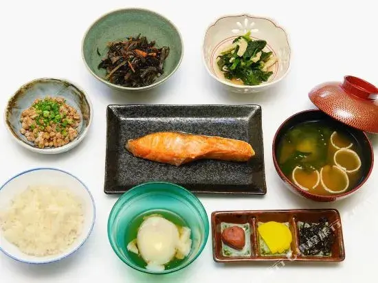 Assortiment de petits plats japonais servis dans des récipients variés.