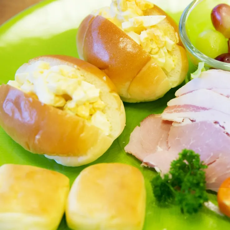 Assiette garnie de petits pains farcis à l'œuf, de jambon et de persil.