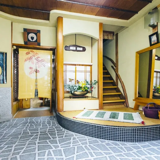 Un intérieur lumineux avec un escalier et une porte décorée.