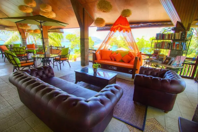 Espace de détente extérieur avec canapés confortables et tables à manger.