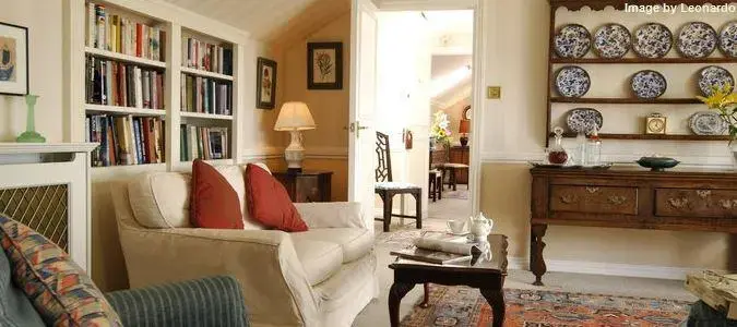 Un salon clair avec une bibliothèque et un buffet décoratif.
