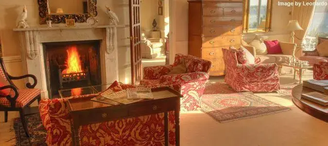 Un salon chaleureux avec une cheminée allumée et des fauteuils confortables.