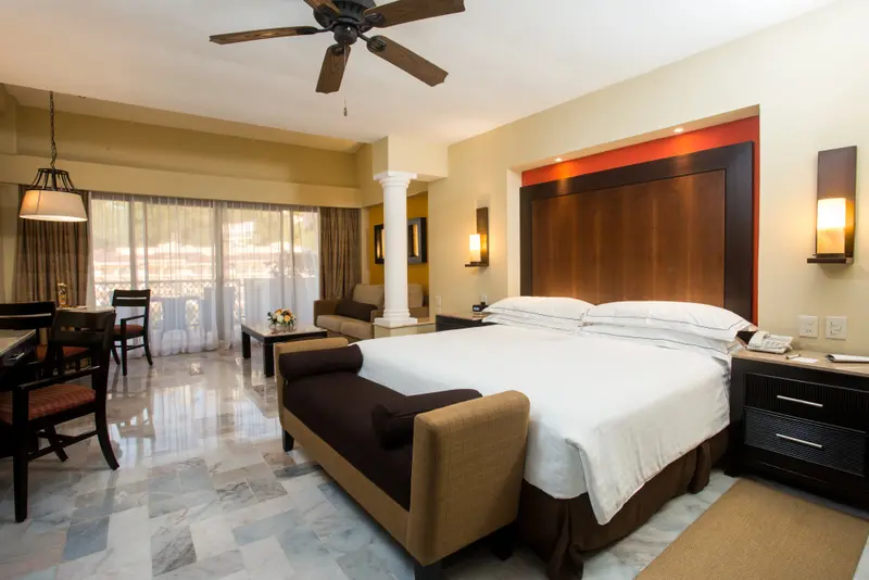 Une chambre spacieuse avec un grand lit et un coin salon.