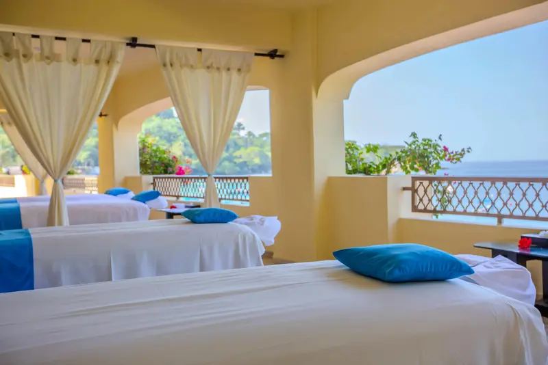 Espace de relaxation avec tables de massage en bord de mer.