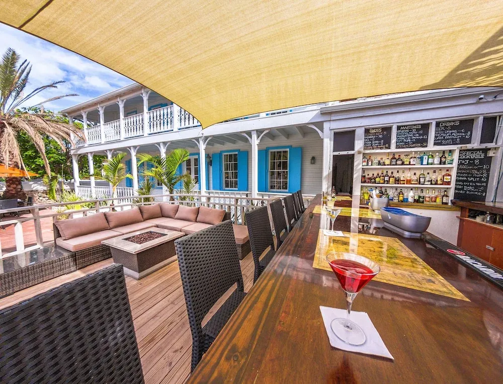 Terrasse ombragée avec un bar et des espaces de détente.