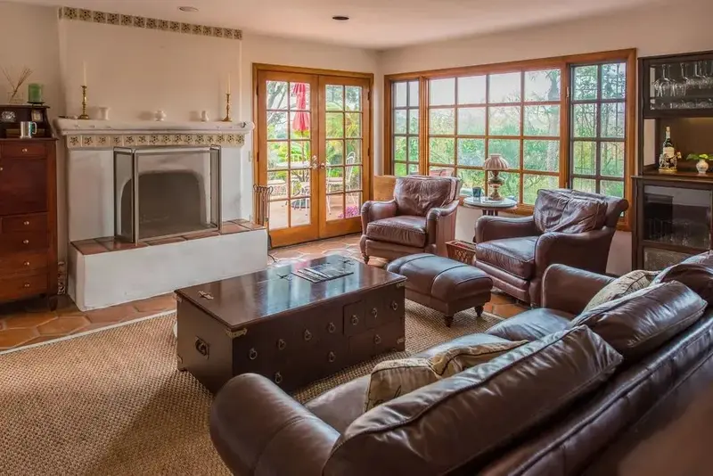 Un salon chaleureux avec des fauteuils en cuir et une cheminée.
